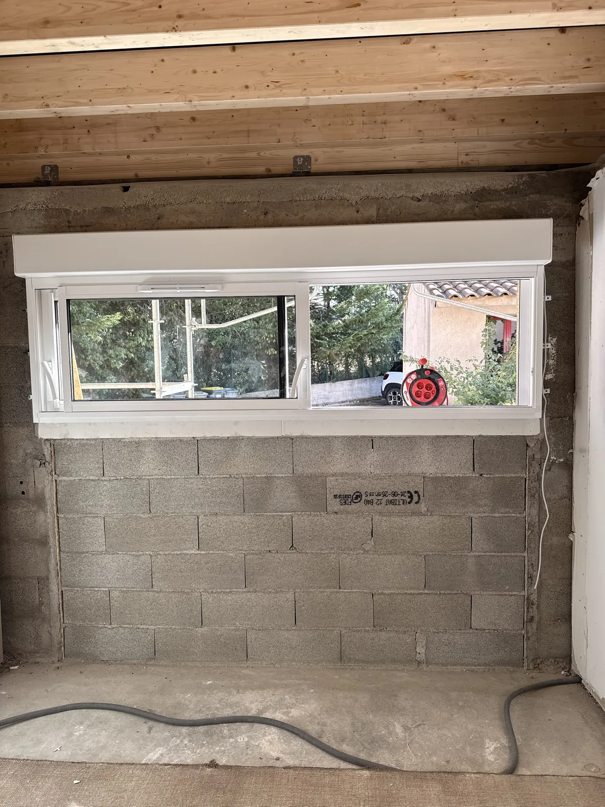 Fenêtre blanche avec coffre de volet roulant, en cours de chantier