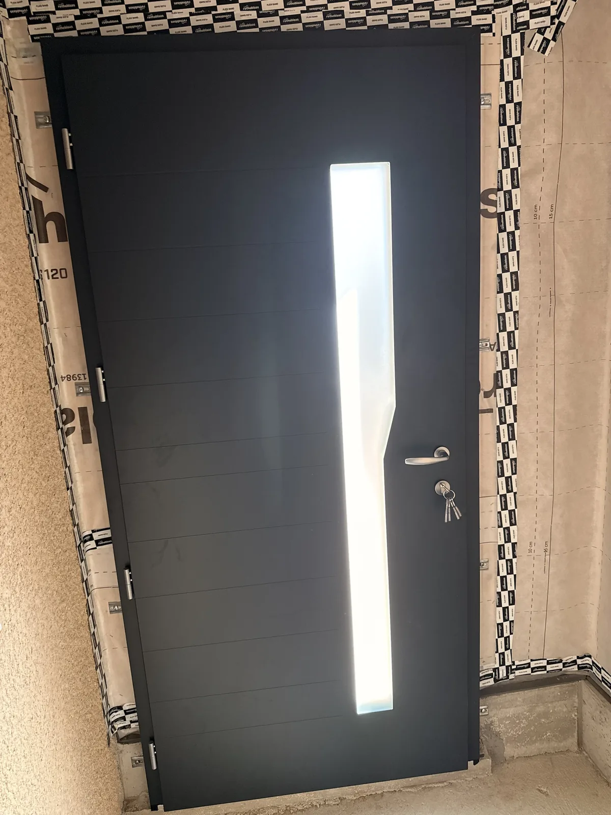 Porte d'entrée en aluminium anthracite avec vitrage vertical, même chantier